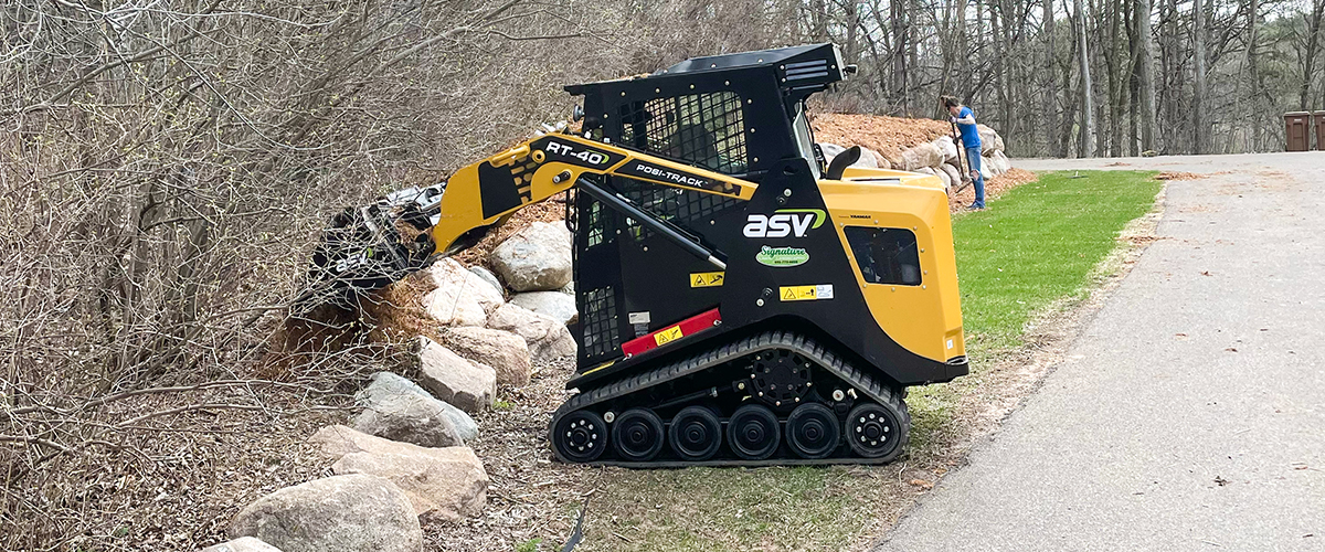 Hardscapes-2 ASV POBI_TRACK machine moving rocks for a rock retaining wall