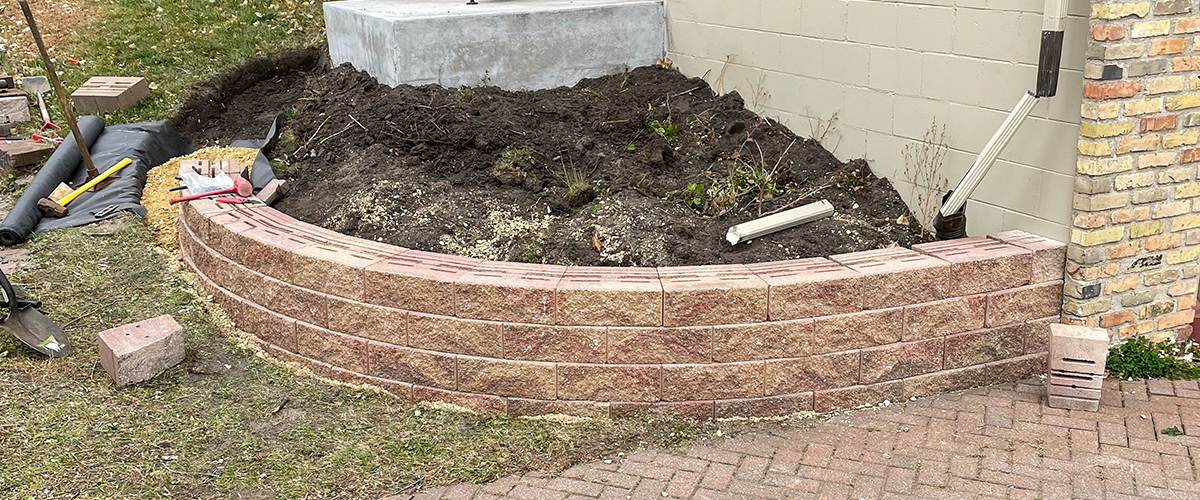 Hardscapes-5 Signature Lawns building a retaining wall for a flower bed.