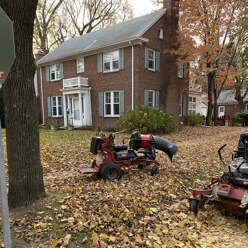Lawn-Maintenance-1 Mower and ride behind leaf blower on a lawn coverd in fall leaves